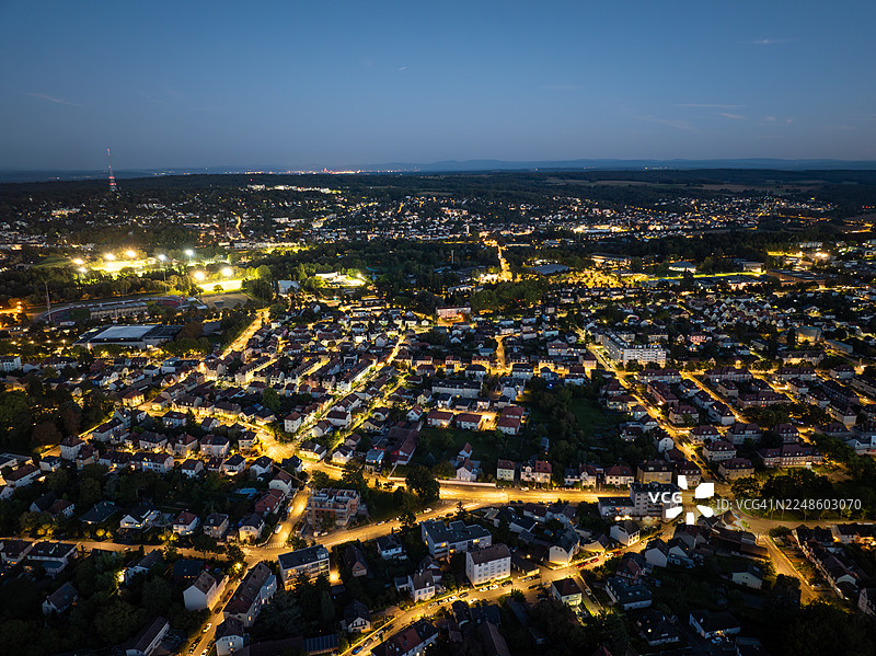 俯视夜间城市灯火辉煌，展现了暮色天空下的城市蔓延和璀璨灯光图片素材