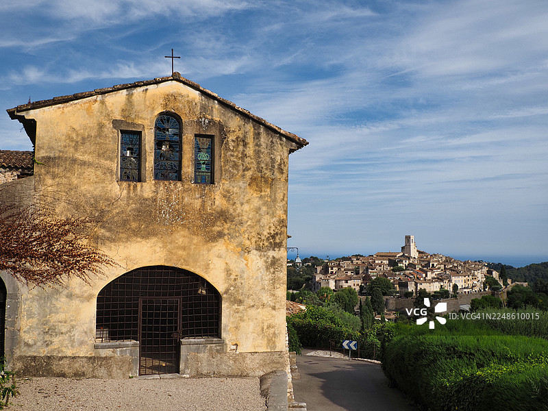 法国普罗旺斯山顶村庄上方俯瞰着带有彩色玻璃的古老教堂图片素材