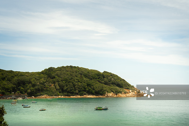 马来西亚停泊岛热带海湾的美景，绿意盎然的山丘，碧绿海水上的船只，明媚的天空图片素材