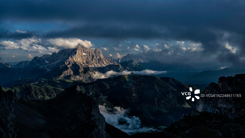 意大利圣维托迪卡多雷，被乌云笼罩的戏剧性山峰，在阴沉的天空下可见的雪块和岩层图片素材
