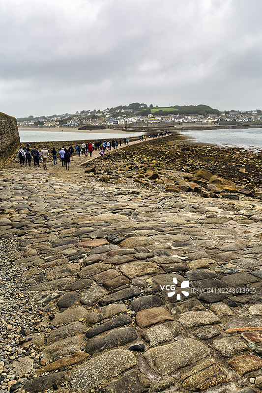 步行者，鹅卵石堤道，圣迈克尔山，潮汐岛，马齐翁，康沃尔，英格兰，英国图片素材