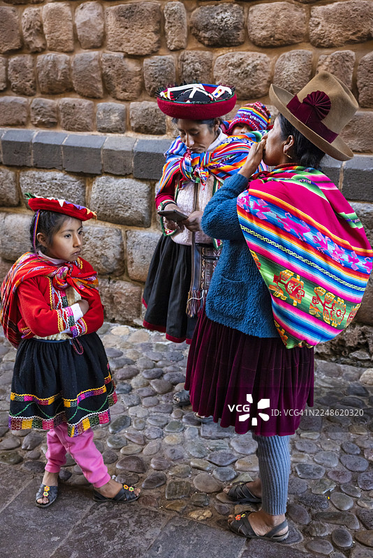 秘鲁妇女身着传统服饰，与孩子们在库斯科合影图片素材