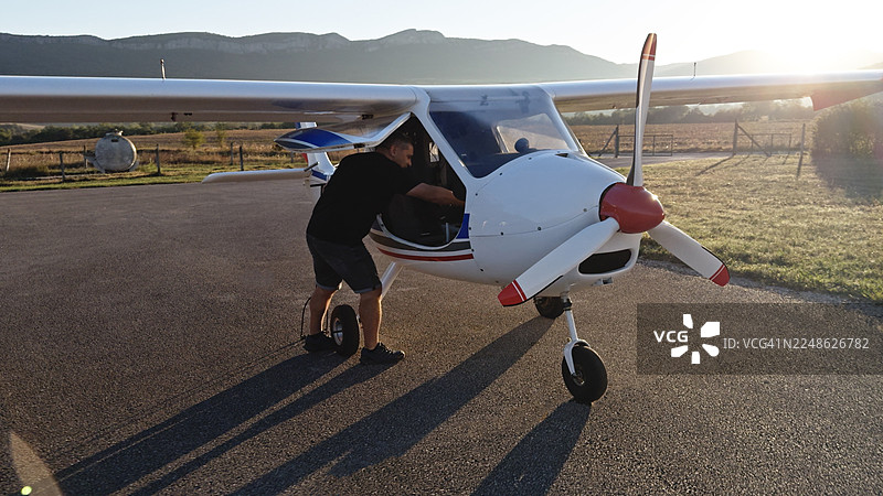 Active Mature Pilot Enters His Personal Aircraft At Sunrise图片素材
