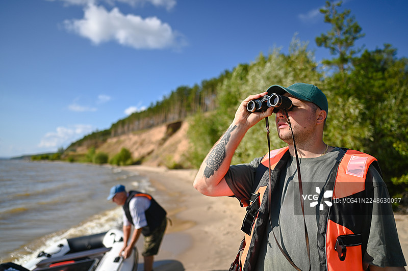 男人们在户外探索，用望远镜观察海岸线图片素材