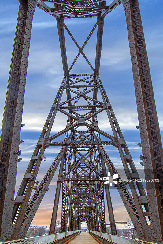 低角度仰拍，一座历史悠久的金属桁架桥，背景是蓝天白云，展现了其精密的结构和引导线，美国，路易斯维尔图片素材