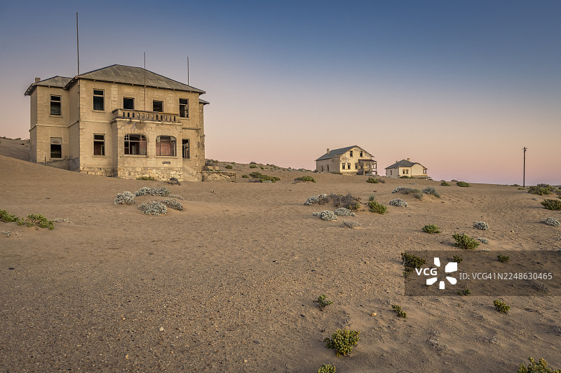 日落时分，晴朗天空下的沙漠风景中的废弃建筑，唤起一种荒凉和历史的沧桑感图片素材