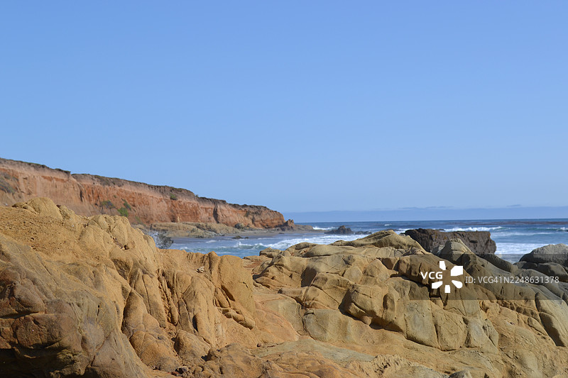 美国圣西蒙崎岖海岸线的风景，海洋上空是晴朗的蓝天，岩石峭壁图片素材
