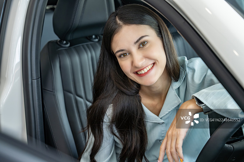 年轻女子在新车里微笑图片素材