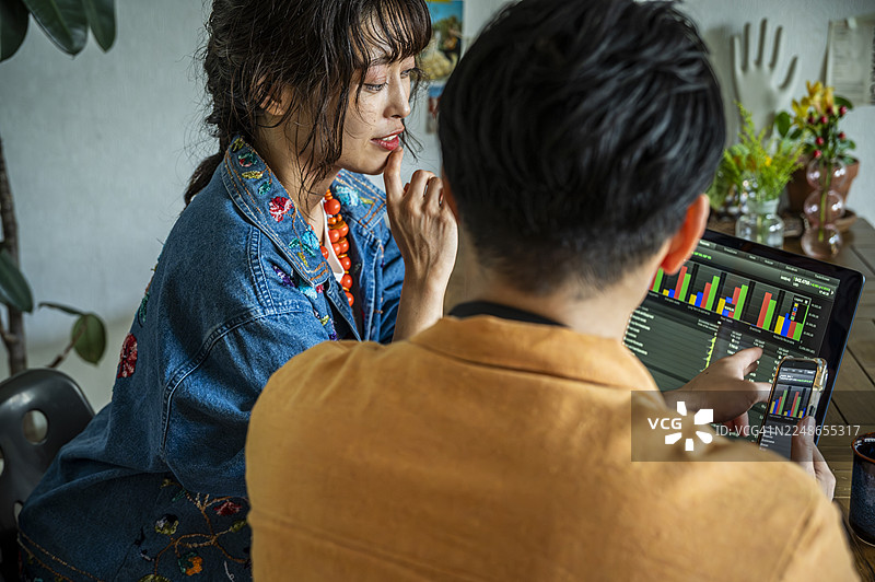 年轻的日本情侣在家里的办公室一起分析财务数据图片素材