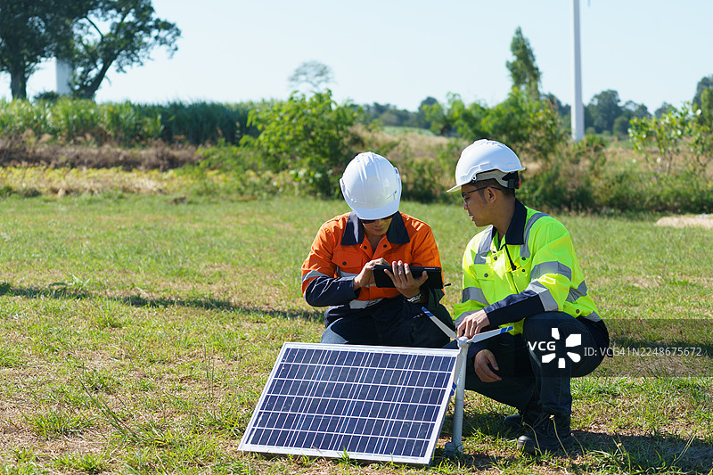 工程师正在检查一座大型风力涡轮机的运行情况，该风力涡轮机正在风力发电场中发电。图片素材