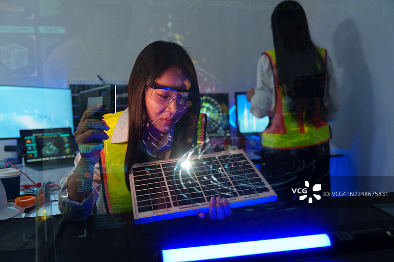 技术人员在实验室分析半导体电路板或微芯片，涉及电子行业、电子工程师以及太阳能风力涡轮机。图片素材