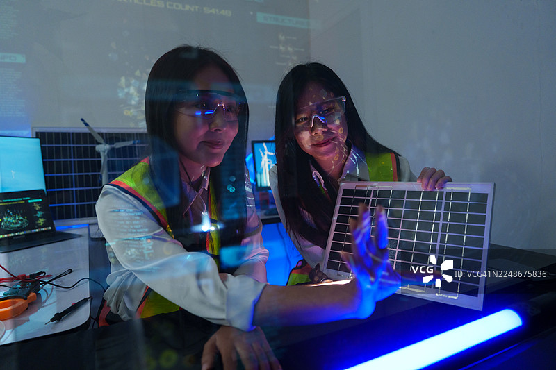 技术人员在实验室中分析半导体电路板或微芯片，涉及电子工业、电子工程师以及太阳能风力涡轮机。图片素材