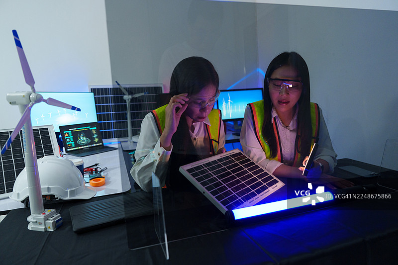 技术人员在实验室中分析半导体电路板或微芯片，涉及电子行业、电子工程师以及太阳能风力涡轮机。图片素材