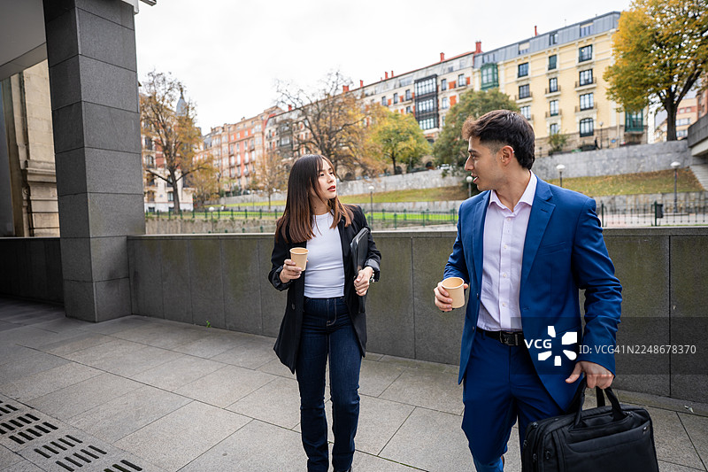 商务同事在咖啡休息时间边走边讨论工作图片素材