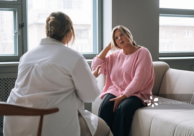 年轻女性在心理咨询中，与女性心理治疗师进行深度对话，获得心理健康支持图片素材