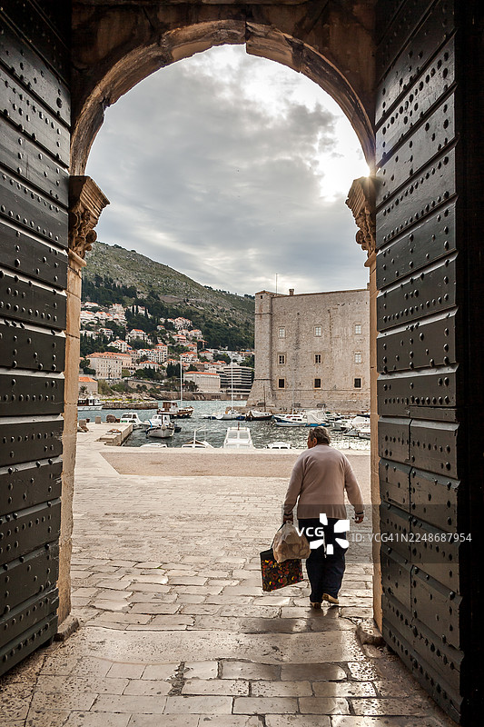 一位女子进入杜布罗夫尼克的老港口图片素材