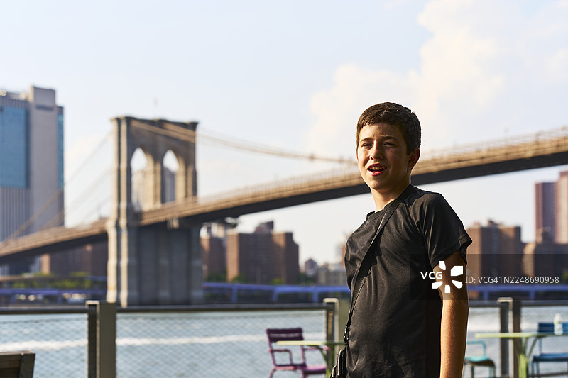 青少年在布鲁克林大桥旁的纽约市滨水区享受时光图片素材
