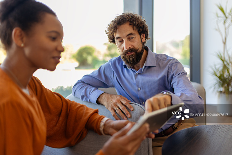 包容性工作场所合作：多族裔专业人士在平板电脑上审阅项目图片素材