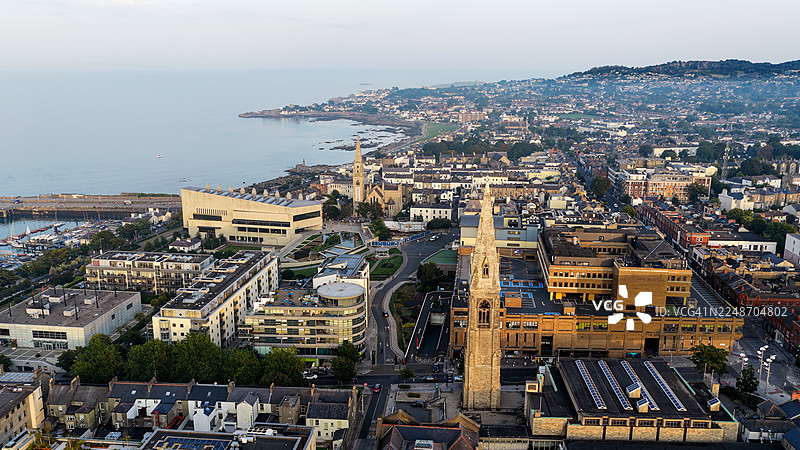 日落时分都柏林海岸郊区邓莱里镇中心的鸟瞰图， featuring 邓莱里-拉斯唐郡议会大楼和圣迈克尔教堂，展现了历史与现代建筑、城市景观和旅行概念。图片素材