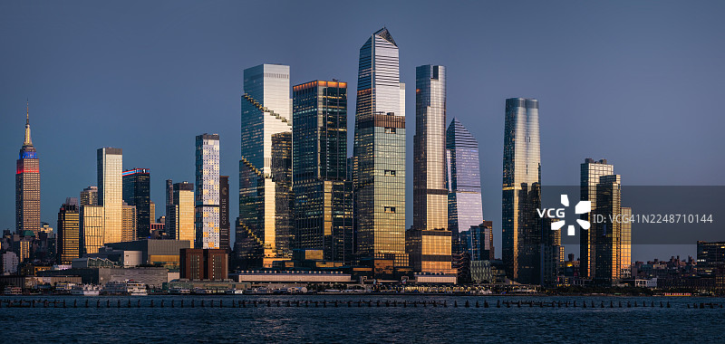 黎明时分，阳光下的摩天大楼从哈德逊河畔拔地而起，矗立在纽约市。图片素材