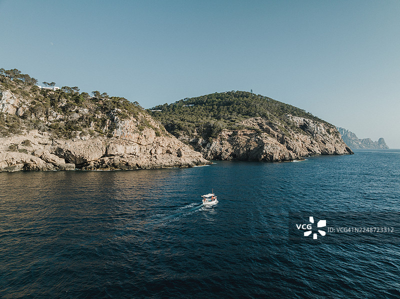 阳光明媚的日子里，伊维萨海岸外的动力帆船航拍图，巴利阿里群岛，西班牙图片素材
