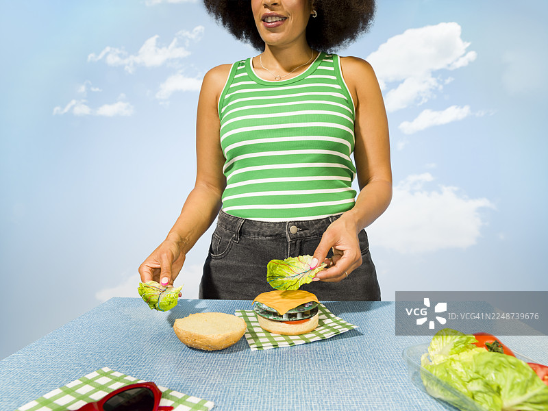 年轻女子用电脑线制作电路板汉堡，配以生菜图片素材