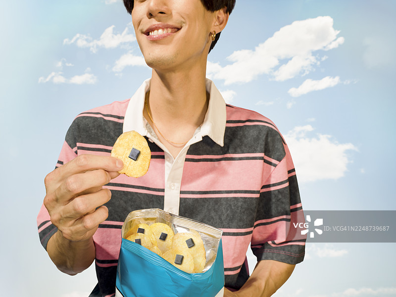 男人一边吃薯片一边看着电脑上的芯片图图片素材