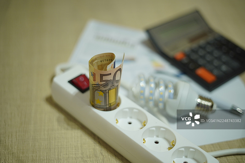 电价，焦点在50欧元纸币上的插线板及虚焦细节图片素材