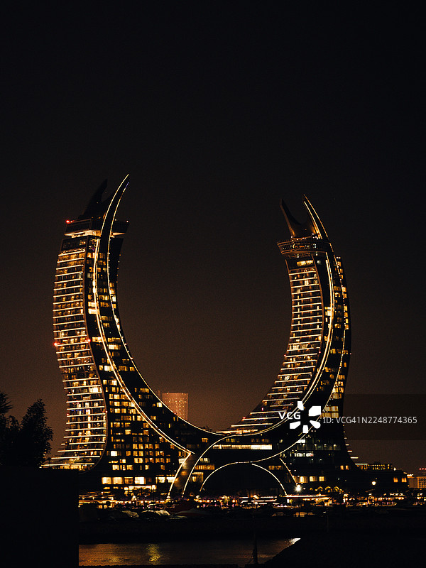 夜幕下的现代摩天大楼，在黑暗的天空中展示着未来主义建筑，卡塔尔，多哈图片素材