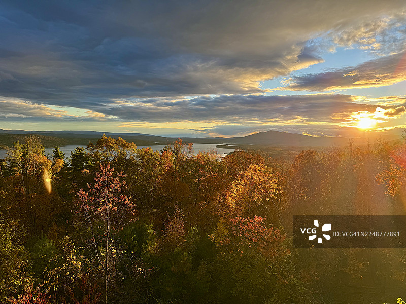 美国伍德斯托克，秋季色彩斑斓的森林和湖泊，映衬着戏剧性的日落天空的风景图片素材