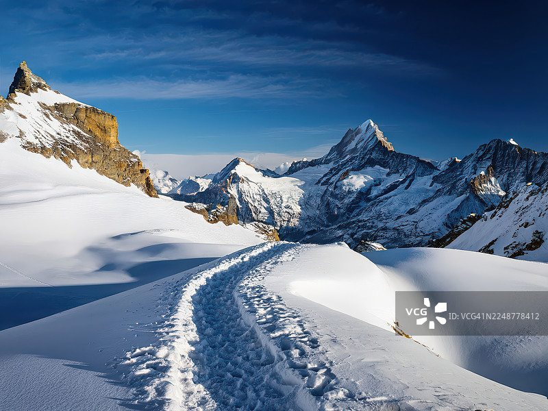 瑞士雪山风光，蓝天白云下蜿蜒小径，小屋图片素材