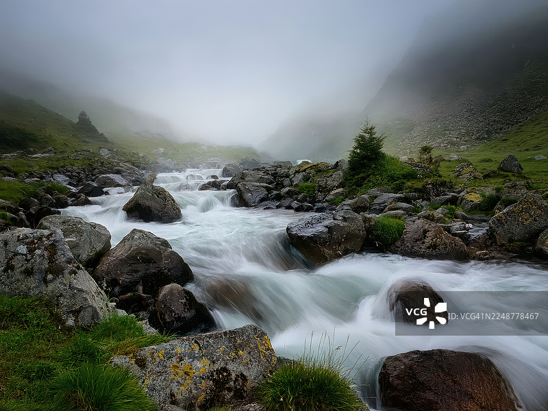 土耳其，薄雾笼罩的山间溪流，水流湍急，岩石长满苔藓，构成一处宁静而神秘的自然景观图片素材