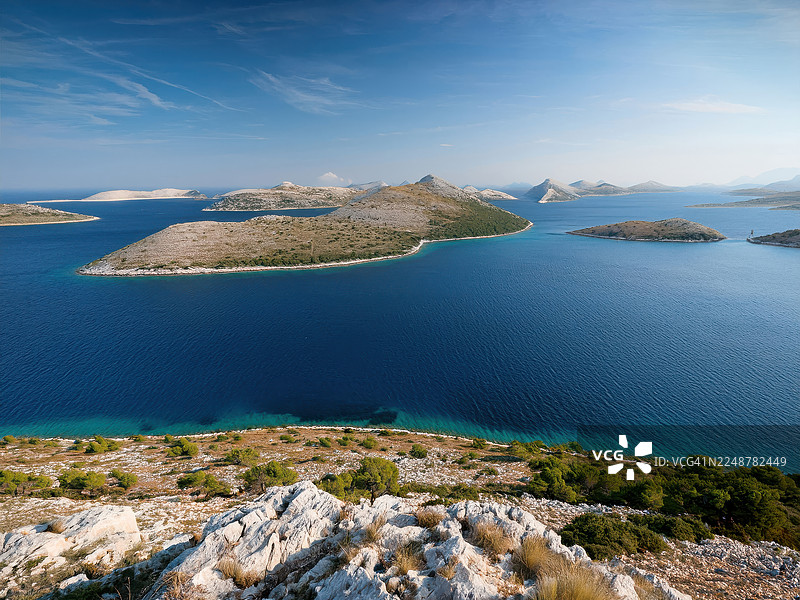 航拍克罗地亚科纳提群岛，蔚蓝大海中点缀着无数岩石岛屿，天空晴朗，海岸风光旖旎图片素材
