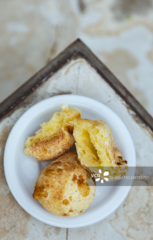 美味的巴西奶酪面包，木薯粉面包（Pao de Queijo），装在白盘中，可供食用图片素材
