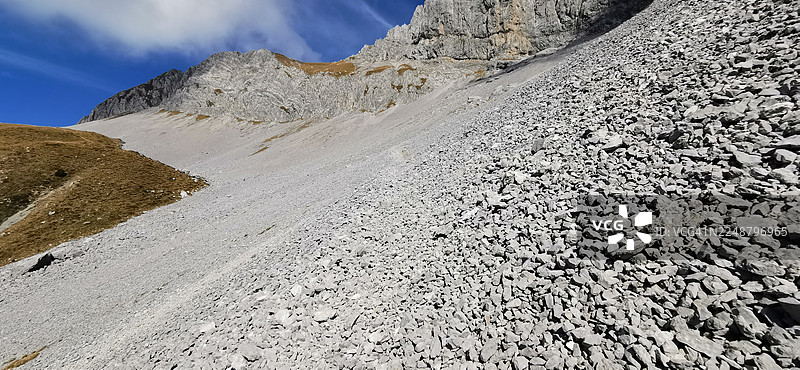 晴朗蓝天下布满浮石的陡峭山坡，展现意大利粗犷的自然之美图片素材