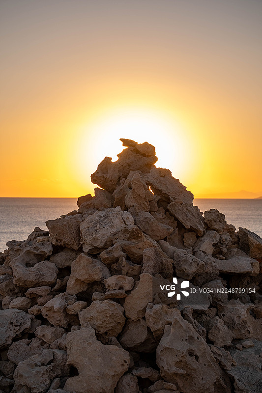 日落时分，海滩上的岩石与天空构成的风景图片素材