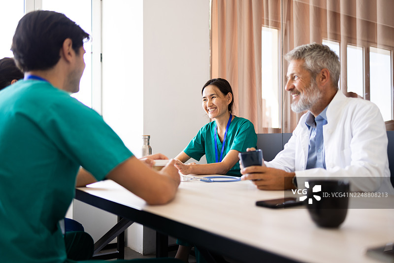 医疗团队在医院会议室开会讨论病人病例图片素材