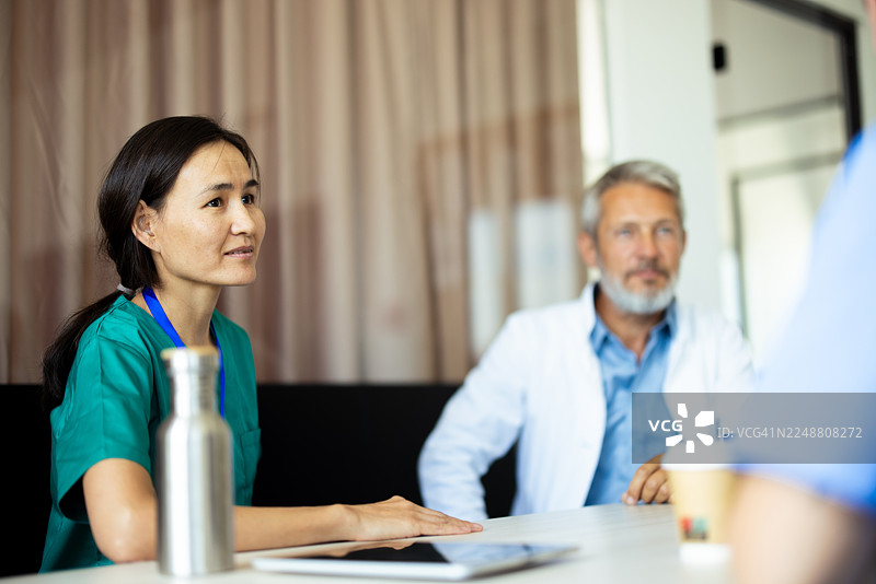 医疗团队会议：医生和护士在医院会议室协作图片素材