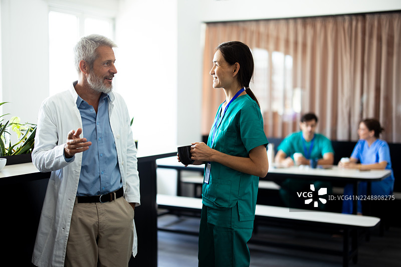 医生和护士在医院食堂的咖啡休息时间交谈图片素材