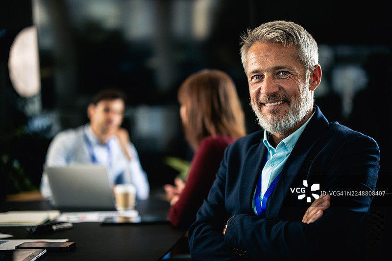 办公室里，一位面带微笑的商人正在主持会议图片素材