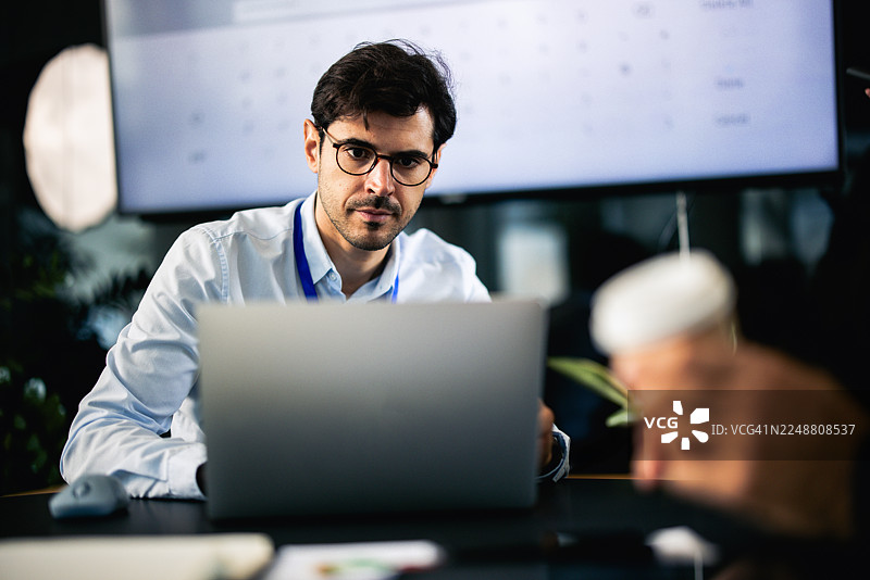 专注的商界人士在办公室深夜使用笔记本电脑工作图片素材