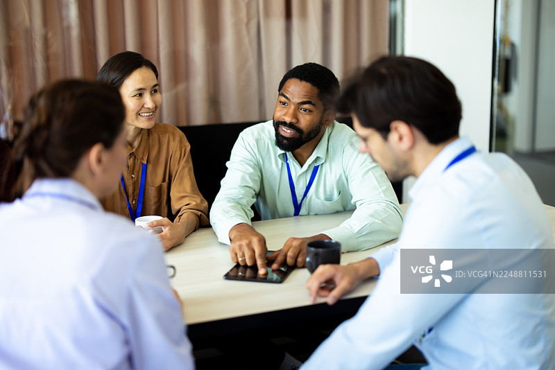 办公室里，商务人士正在使用数字平板电脑开会图片素材