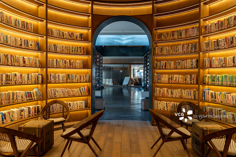 黄光照亮的图书馆墙壁上摆放着许多书籍图片素材