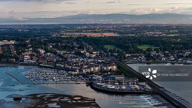 爱尔兰都柏林马拉海德码头和海岸住宅区的日落航拍景观，船只停泊在平静水面整齐的队列中，传统海滨城镇布局，拥有现代公寓和风景如画的自然河口，旅行和生活方式概念图片素材