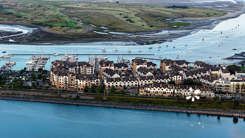 爱尔兰都柏林马拉海德码头和海岸住宅区的日落鸟瞰图，平静的水面上船只整齐地停泊在码头，传统的海滨城镇布局，现代公寓和风景优美的自然河口，旅行和生活方式的概念图片素材