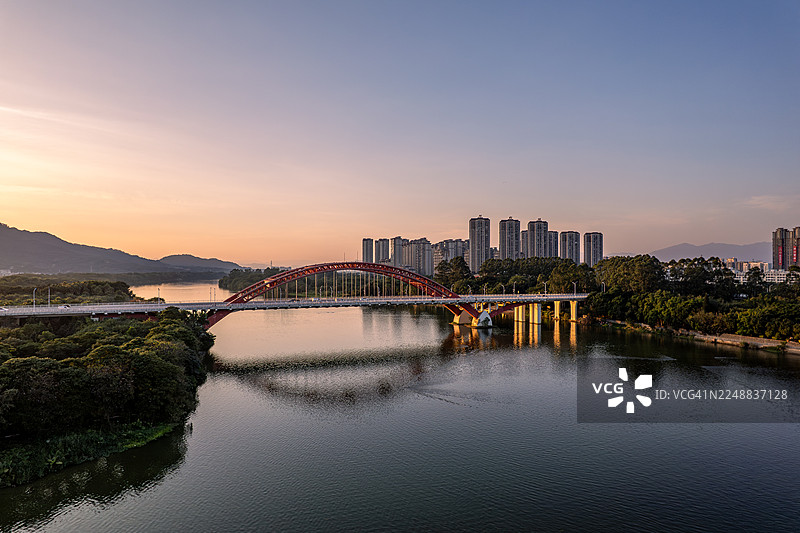 黄昏时分，河流旁的城市建筑和桥梁的航拍照片图片素材