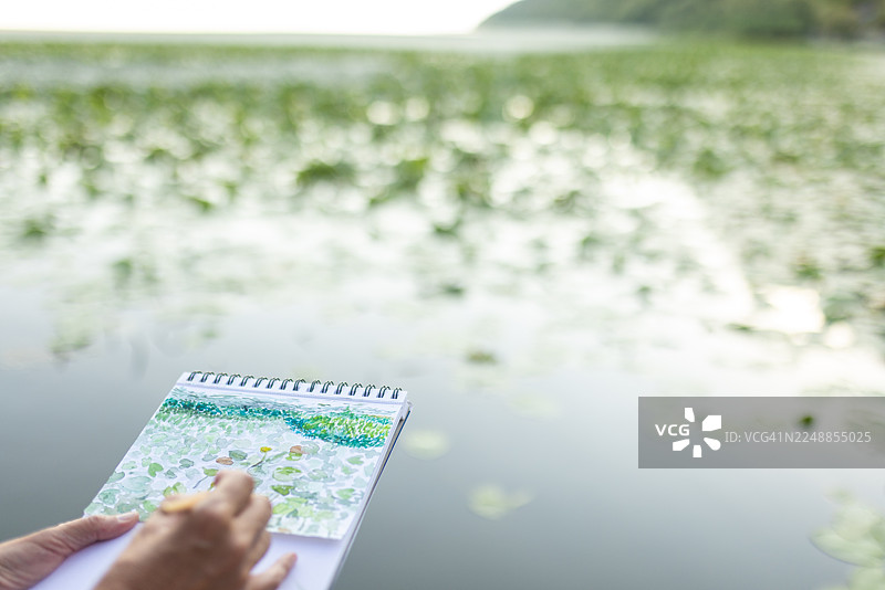 女子清晨在湖边享受水彩画创作图片素材