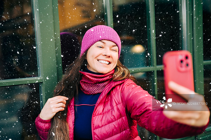 快乐的女人在雪天的户外自拍图片素材