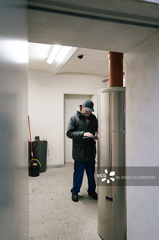 一名建筑技术人员正在检查住宅楼的供暖系统图片素材