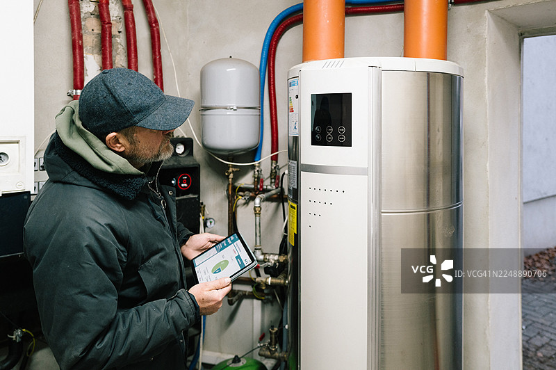 一名建筑技术人员正在检查住宅楼的供暖系统图片素材